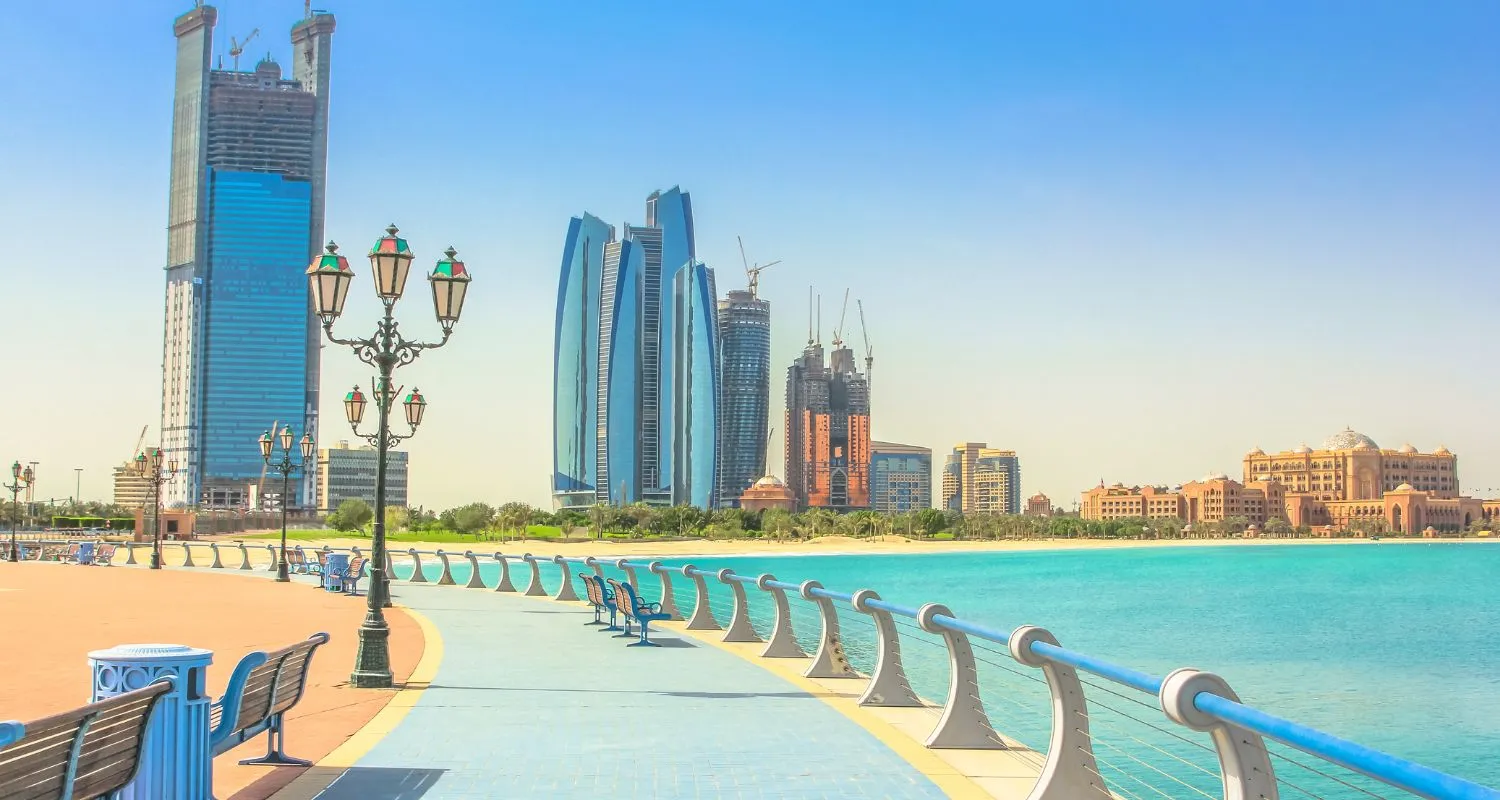 Corniche Beach promenade with turquoise water and Abu Dhabi skyline in the background