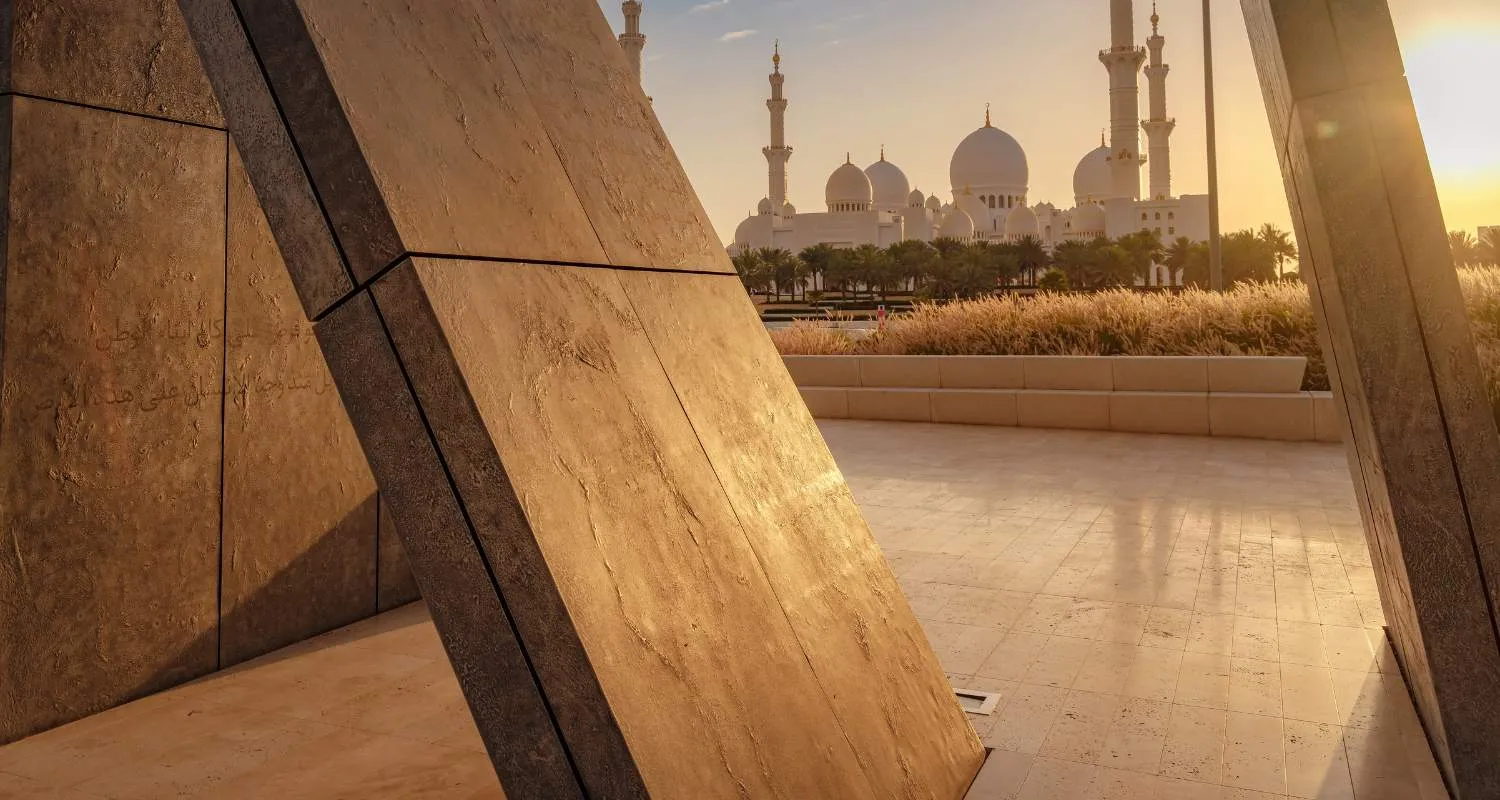 Wahat Al Karama memorial framing Sheikh Zayed Grand Mosque at sunset, among meaningful Abu Dhabi attractions