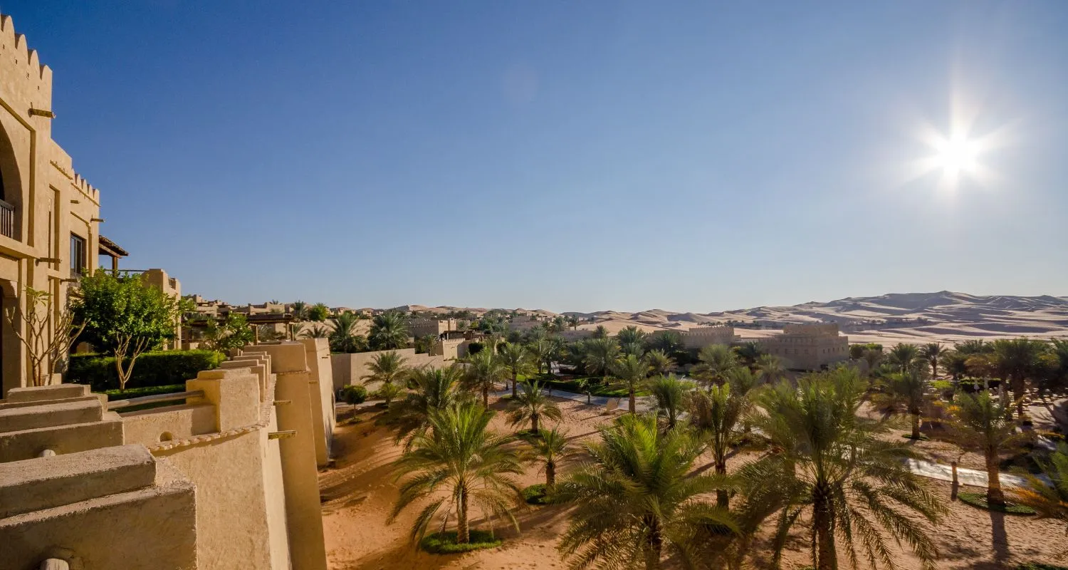 Desert fort with palm gardens backed by the golden dunes of Liwa in Abu Dhabi