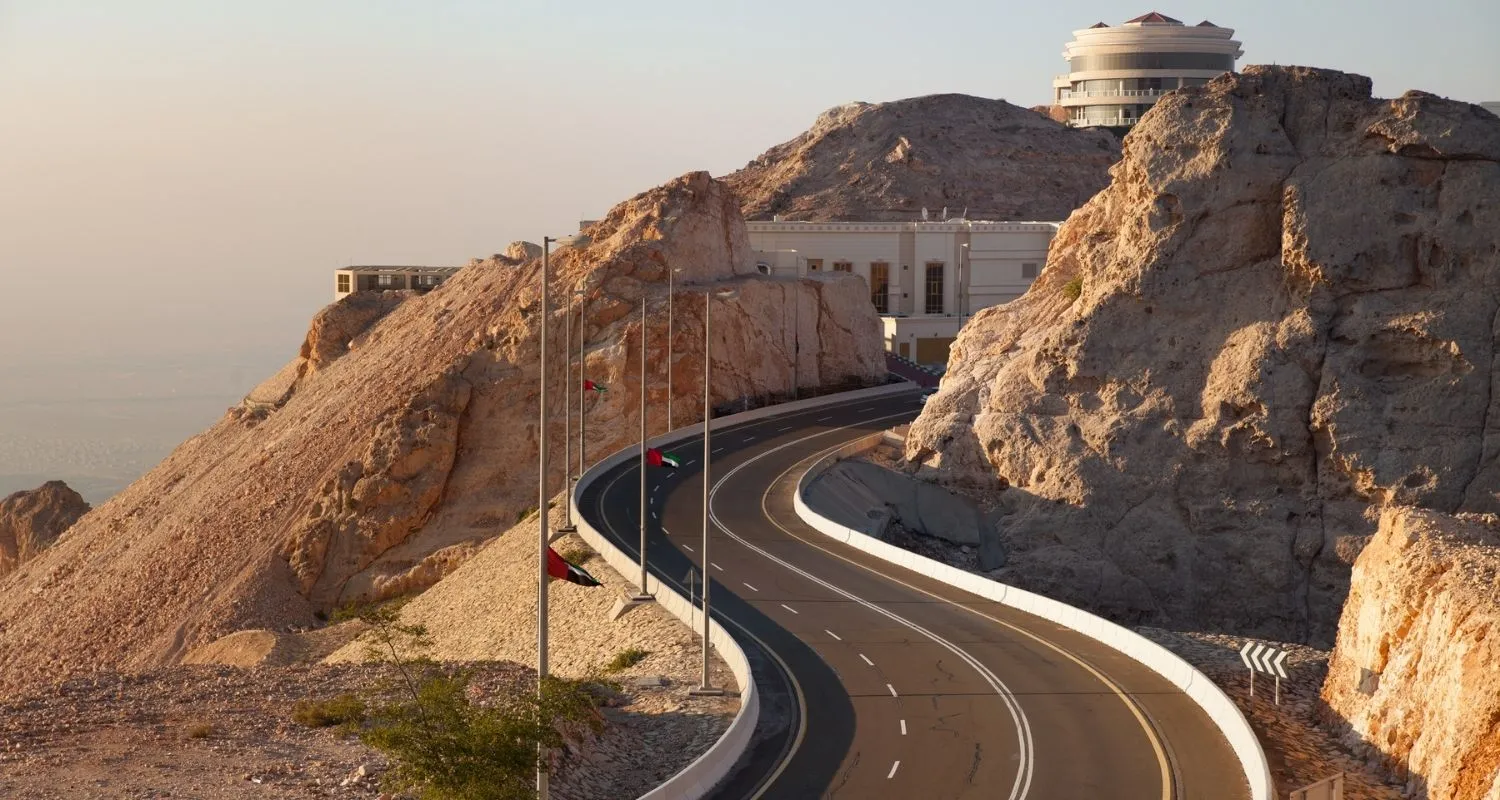 Switchbacks of the Jebel Hafeet road climbing past rocky cliffs toward the summit